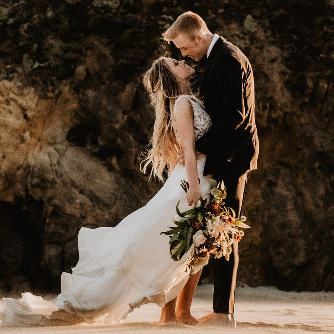 Elopement couple on beach in Big Sur California with artificial and dried flower bouquet